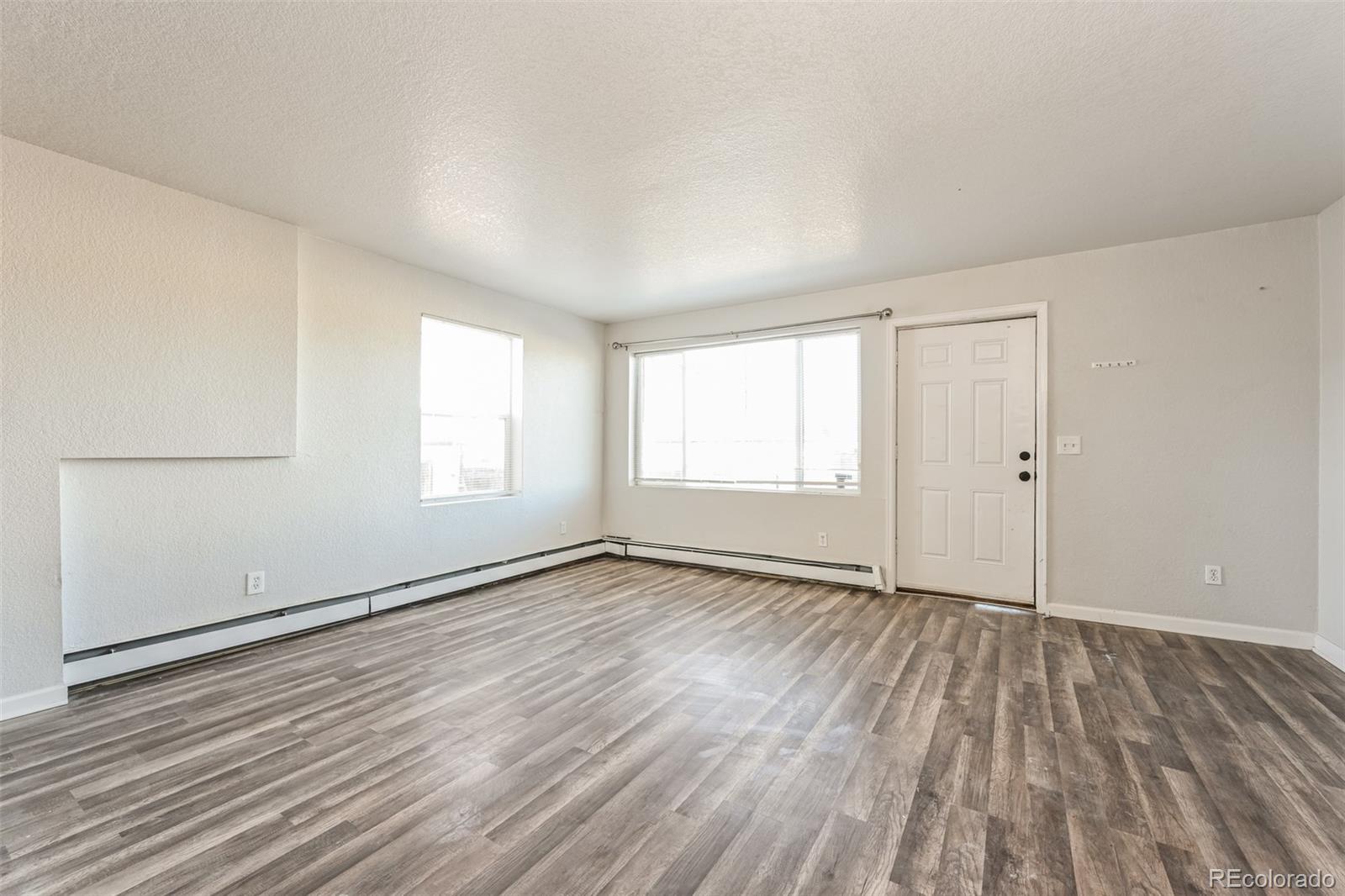 3210 West Longfellow Place Denver, CO 80221 - Photo 17 of 36 an empty room with wooden floor and windows