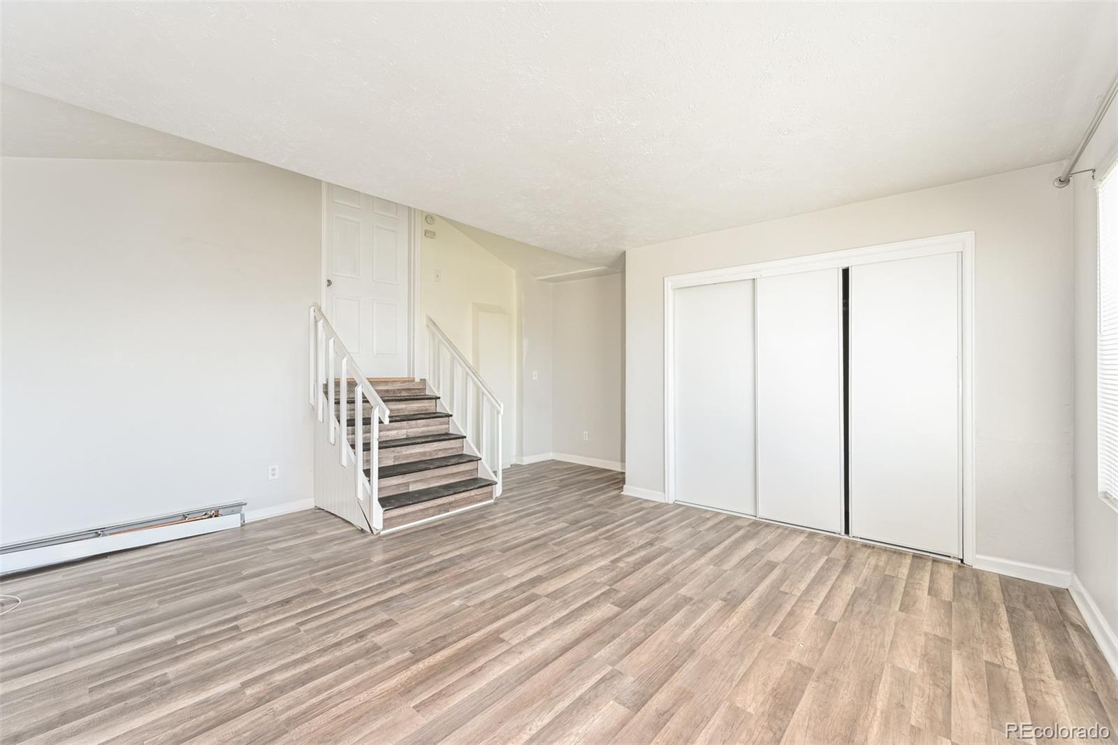 3210 West Longfellow Place Denver, CO 80221 - Photo 19 of 36 a view of a room with wooden floor and white walls