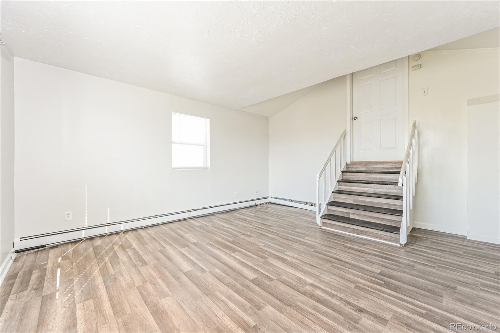 3210 West Longfellow Place Denver, CO 80221 - Photo 20 of 36 a view of an empty room with wooden floor and stairs