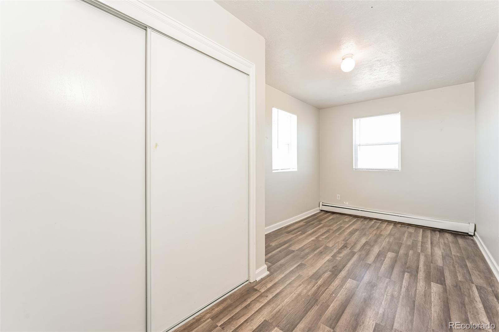 3210 West Longfellow Place Denver, CO 80221 - Photo 22 of 36 an empty room with wooden floor and windows