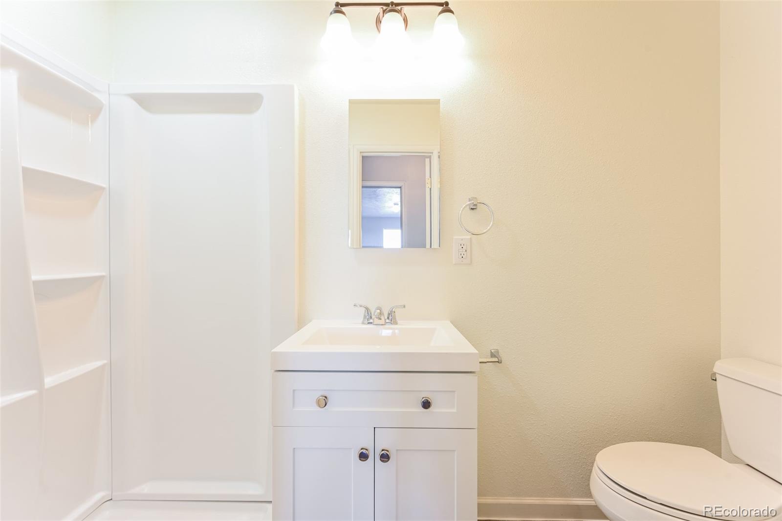 3210 West Longfellow Place Denver, CO 80221 - Photo 23 of 36 a bathroom with a sink toilet and mirror