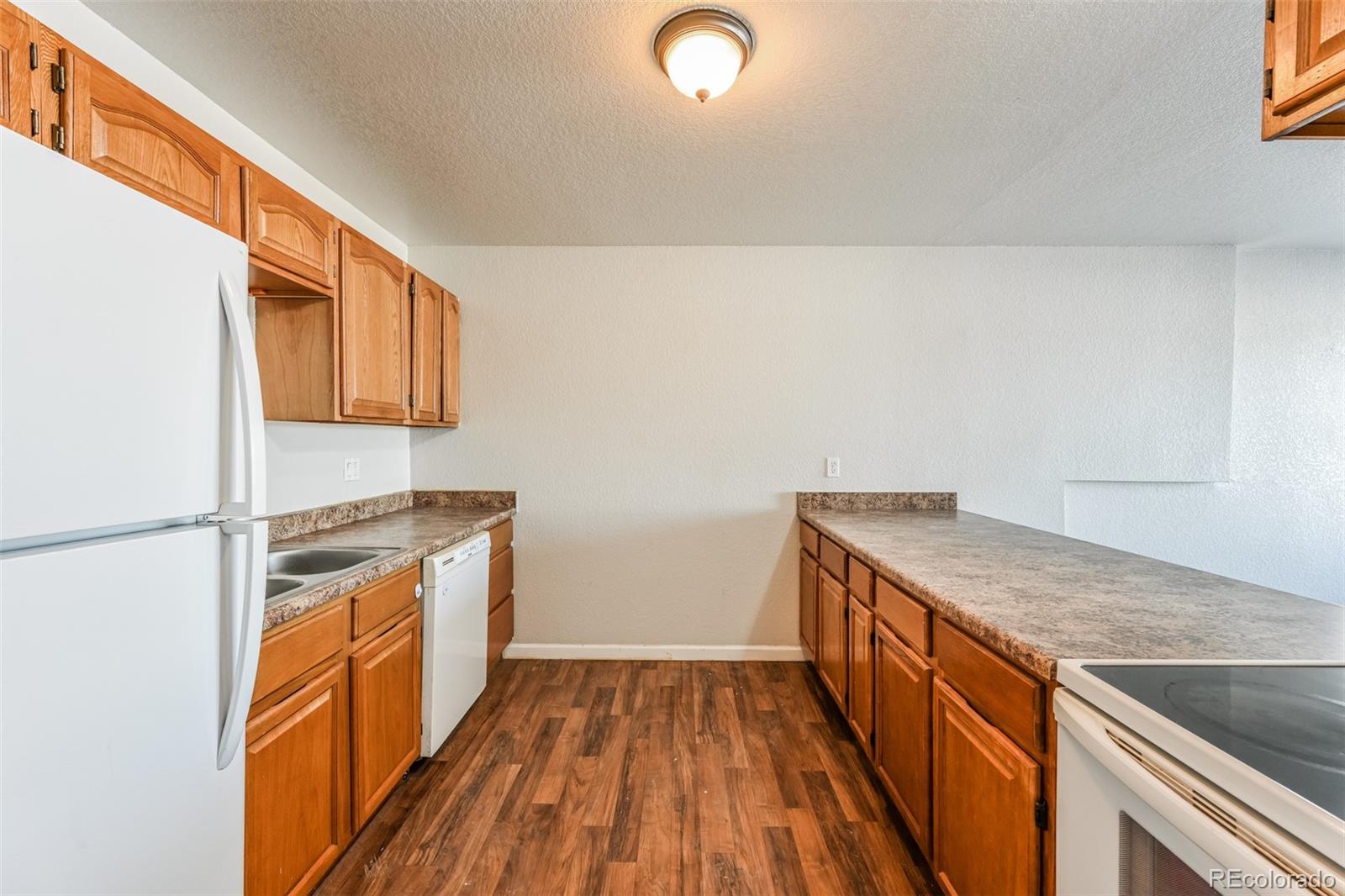 3210 West Longfellow Place Denver, CO 80221 - Photo 25 of 36 a kitchen with granite countertop a sink and a stove top oven