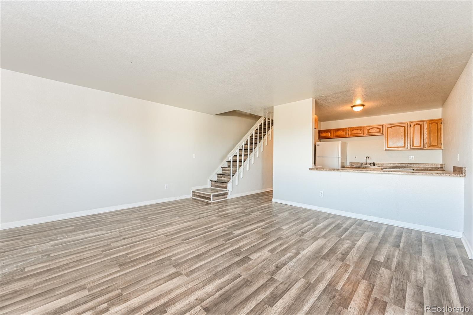3210 West Longfellow Place Denver, CO 80221 - Photo 26 of 36 a view of an empty room with wooden floor and stairs