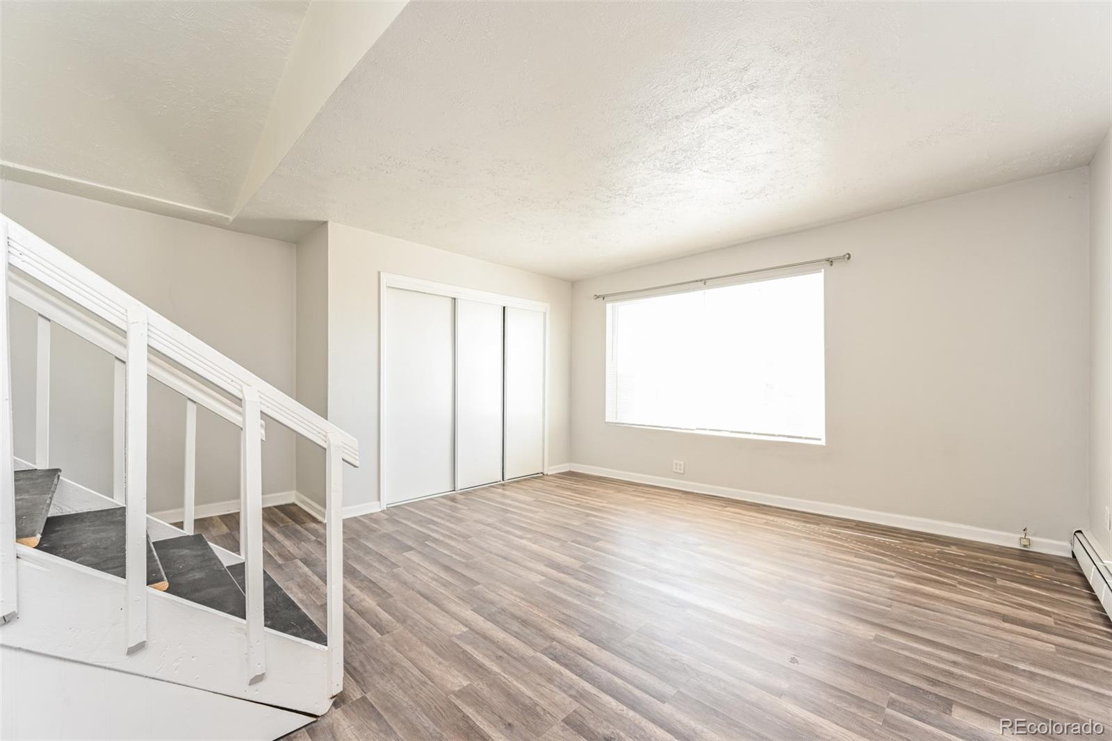 3210 West Longfellow Place Denver, CO 80221 - Photo 27 of 36 a view of an empty room with wooden floor and a window