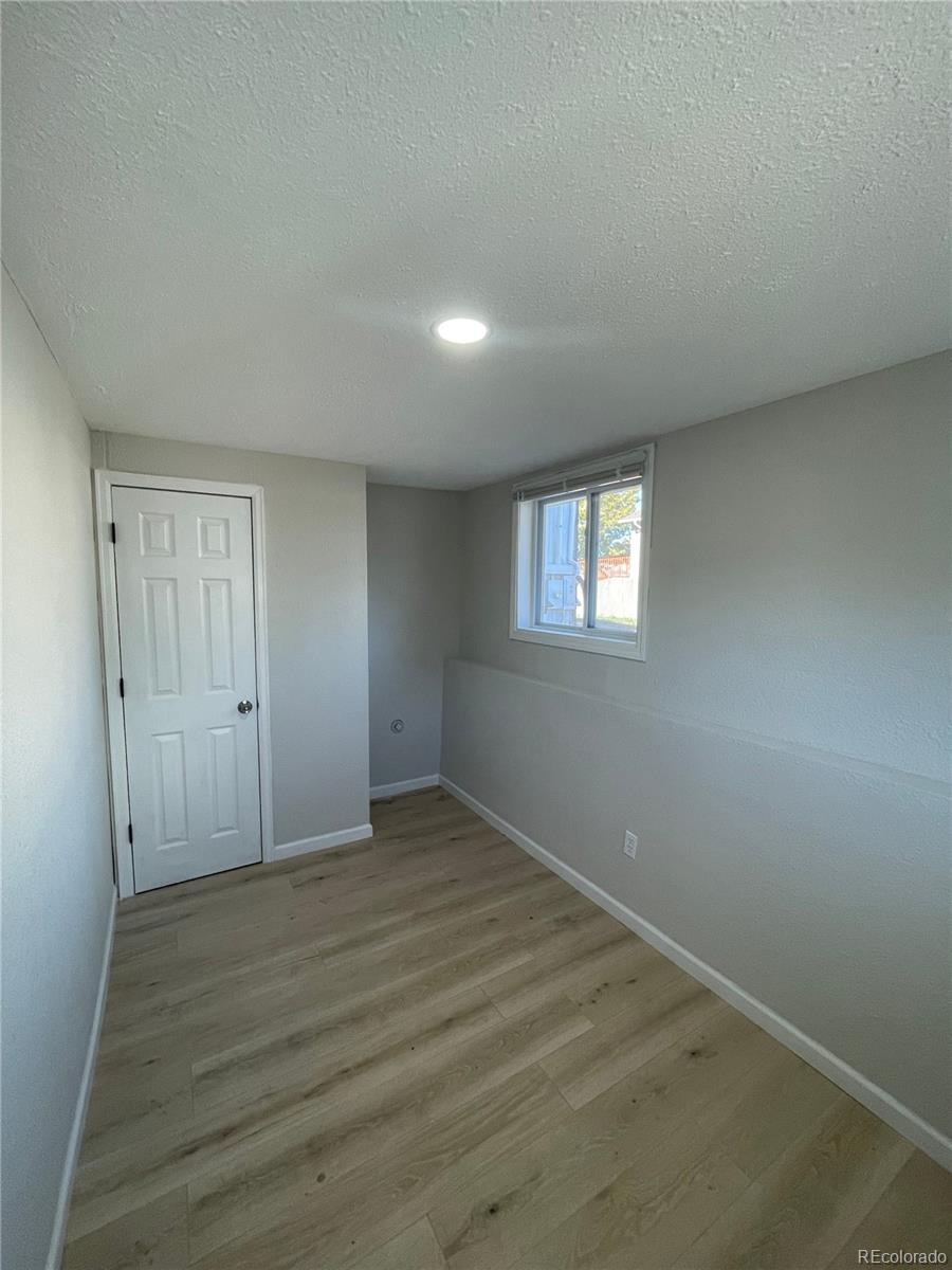 3210 West Longfellow Place Denver, CO 80221 - Photo 7 of 36 an empty room with wooden floor and windows