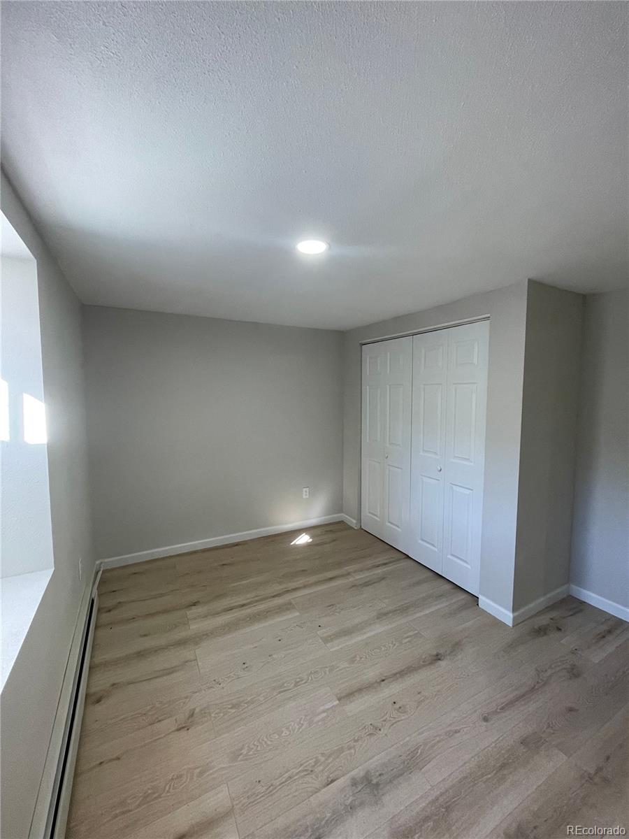 3210 West Longfellow Place Denver, CO 80221 - Photo 9 of 36 an empty room with wooden floor and windows