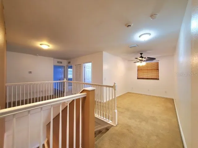 an empty room with windows and fan