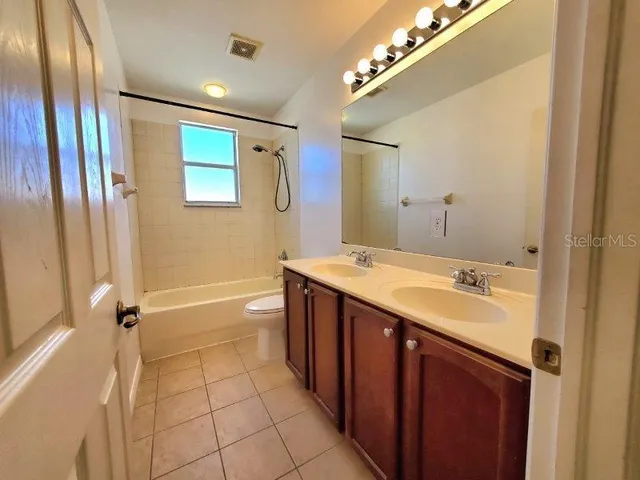 an empty room with window and ceiling fan