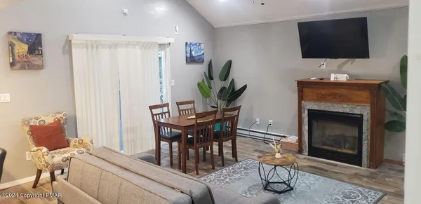 a living room with furniture a flat screen tv and a fireplace