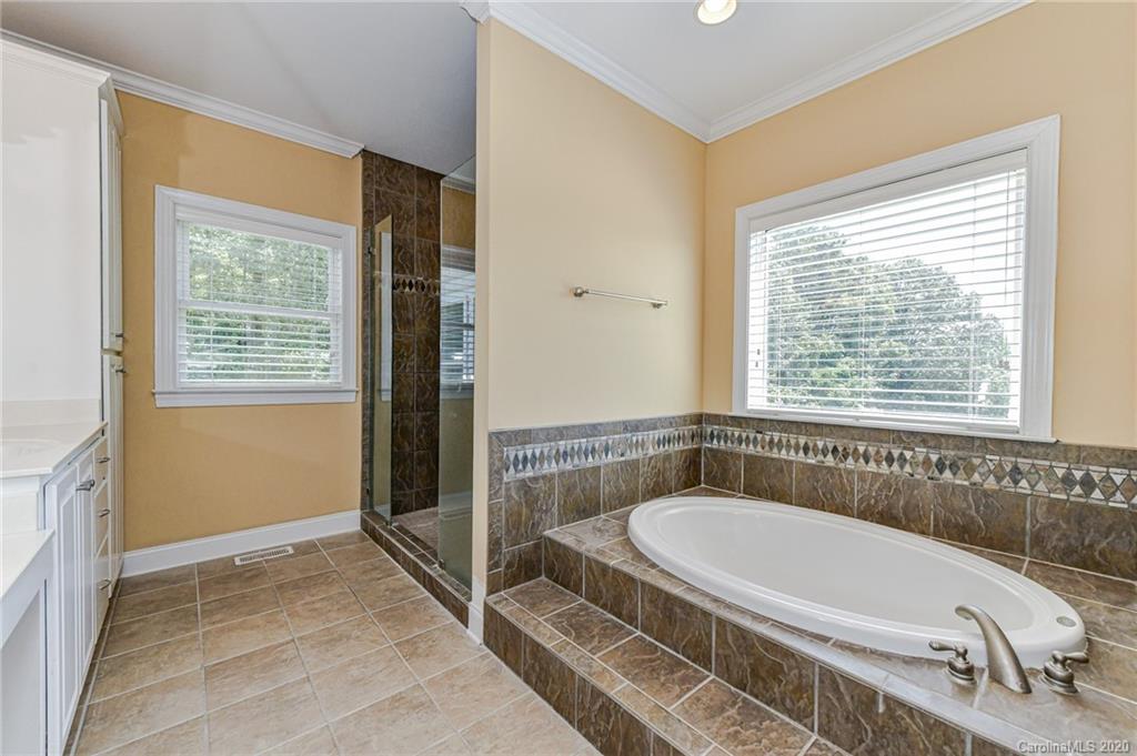 150 North Moose Road Mount Pleasant, NC 28124 - Photo 14 of 32 a bathroom with a tub a sink and a window