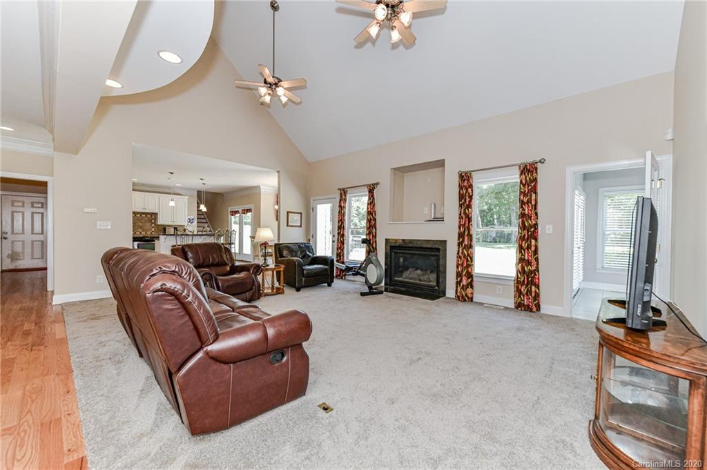 150 North Moose Road Mount Pleasant, NC 28124 - Photo 4 of 32 a living room with furniture a fireplace and a chandelier