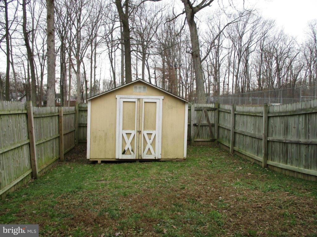 818 Thimbleberry Road Baltimore, MD 21220 - Photo 11 of 12 a view of backyard with large trees and wooden fence