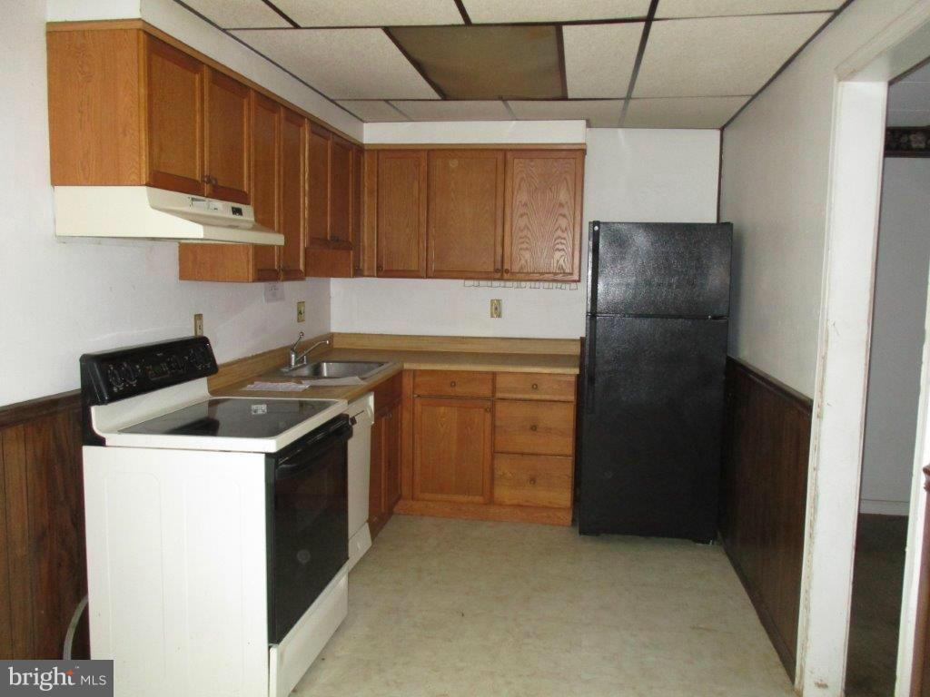 818 Thimbleberry Road Baltimore, MD 21220 - Photo 3 of 12 a kitchen with a stove sink and cabinets
