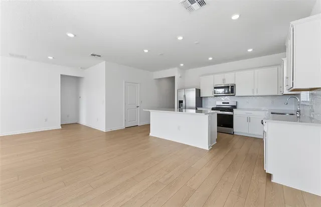 a view of a kitchen with a sink and wooden floor