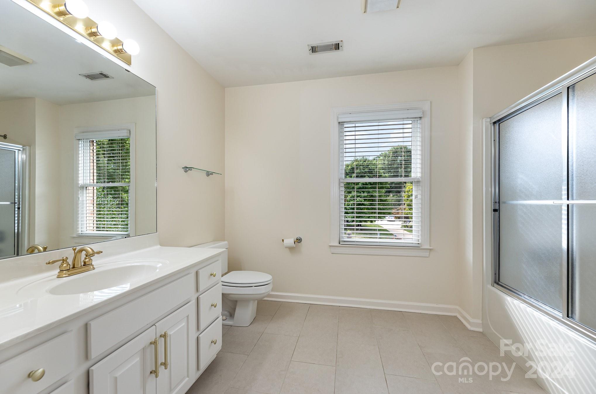 127 Polo Drive Salisbury, NC 28144 - Photo 20 of 31 a bathroom with a granite countertop sink toilet a large mirror and shower