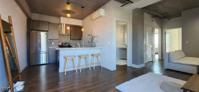 a kitchen with stainless steel appliances wooden floor and a refrigerator