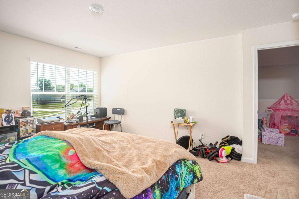 653 Meadows Farm Way Monroe, GA 30655 - Photo 26 of 34 a bedroom with a bed and a table