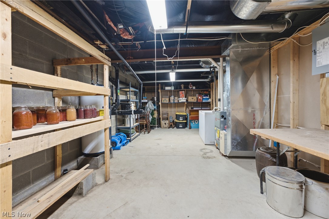 6828 Angling Road Wooster, OH 44691 - Photo 29 of 43 Unfinished basement featuring concrete flooring, exposed utility lines, and ample built-in shelving