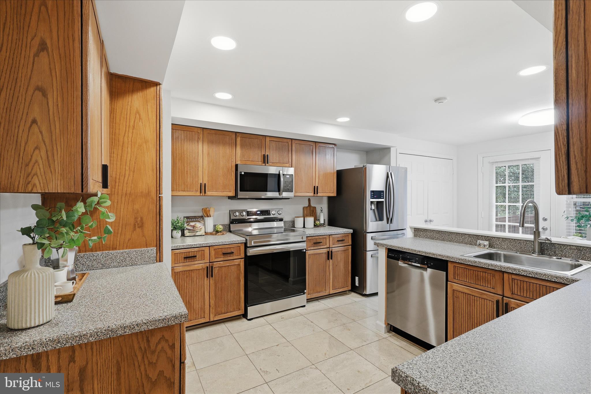 11725 Arbor Glen Way Reston, VA 20194 - Photo 10 of 63 a kitchen with stainless steel appliances granite countertop a sink a stove top oven a refrigerator with wooden floors