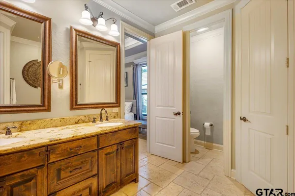 a spacious bathroom with a granite countertop sink mirror and a toilet