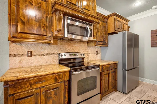 a kitchen with stainless steel appliances granite countertop a stove a refrigerator and a microwave