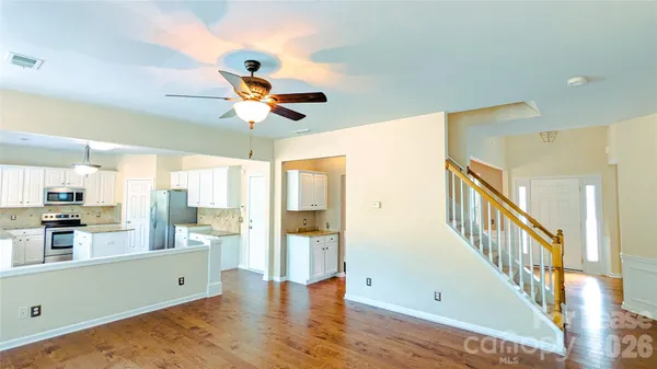 a view of a kitchen with wooden floor and a ceiling fan