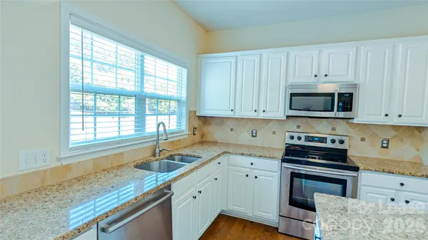 a kitchen with granite countertop a sink and a stove