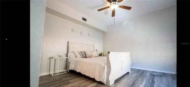 a bedroom with a bed and a ceiling fan