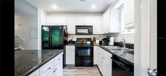 a kitchen with a sink stove and cabinets