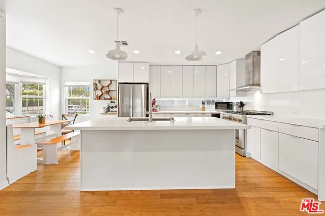a kitchen with kitchen island a sink and a stove