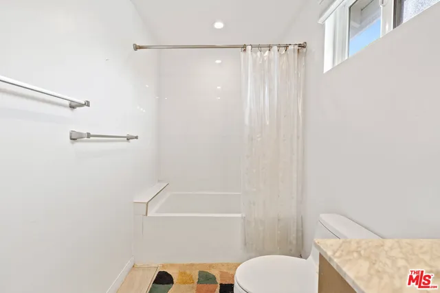 a bathroom with a shower curtain and a toilet