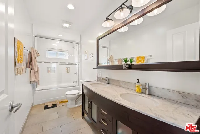 a bathroom with a granite countertop sink mirror and bathtub