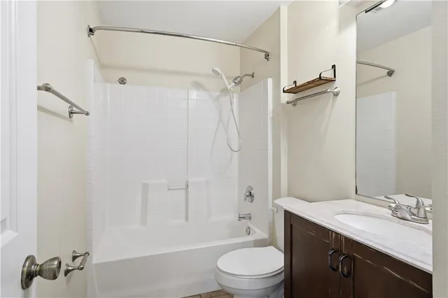 a bathroom with a granite countertop sink a toilet and shower