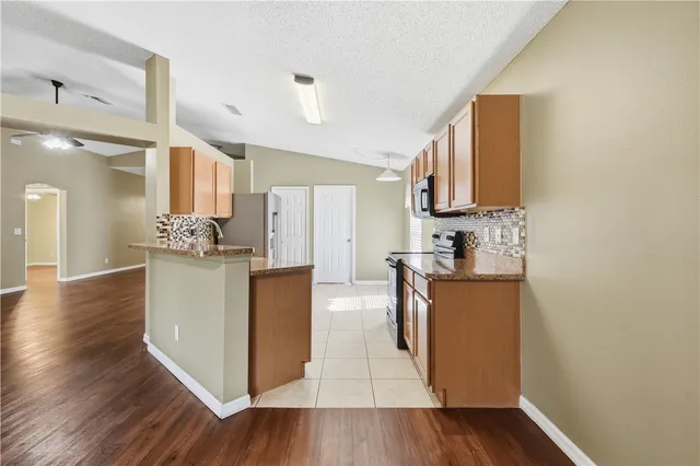 a kitchen with cabinets and wooden floor