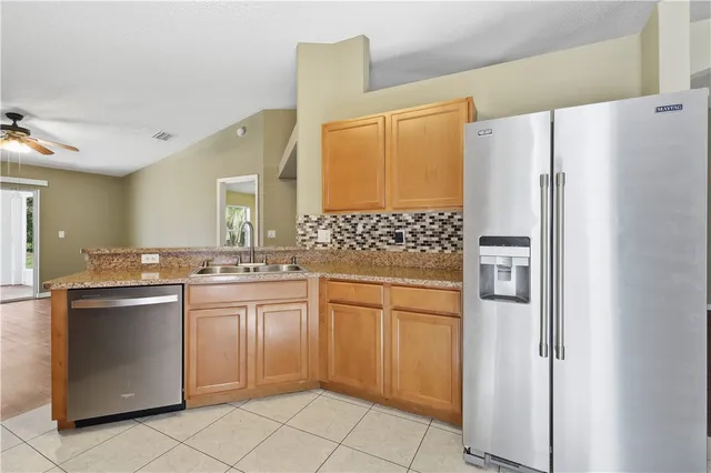 a kitchen with stainless steel appliances a refrigerator sink and cabinets