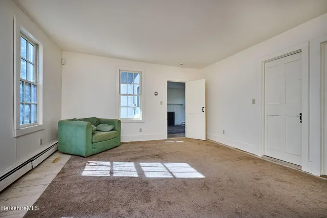 a view of a room with wooden floor and windows