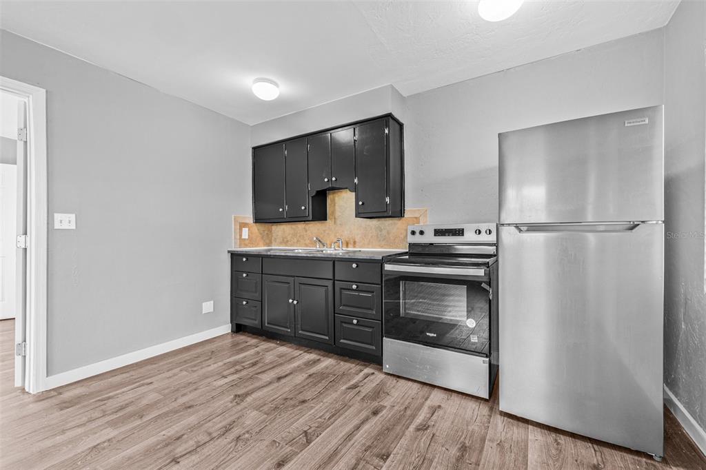 30 Lynn Way Madeira Beach, FL 33708 - Photo 2 of 16 a kitchen with a refrigerator and a stove top oven