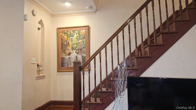a view of staircase with wooden floor and white walls