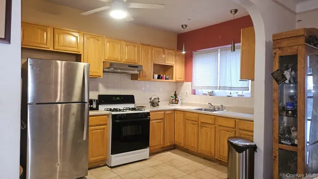 a kitchen with stainless steel appliances granite countertop a refrigerator a stove a sink and a microwave