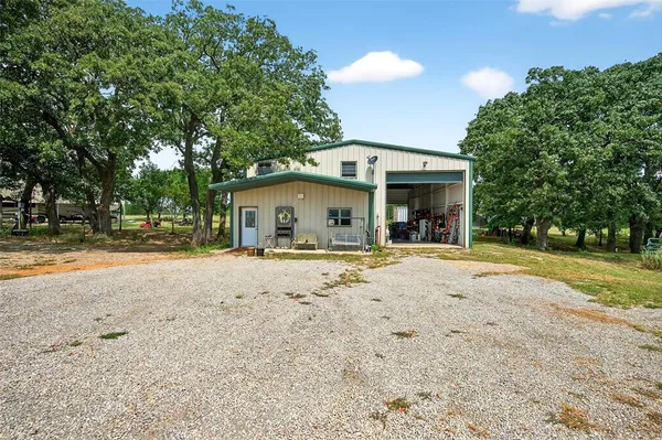 a view of a house with a yard and large tree