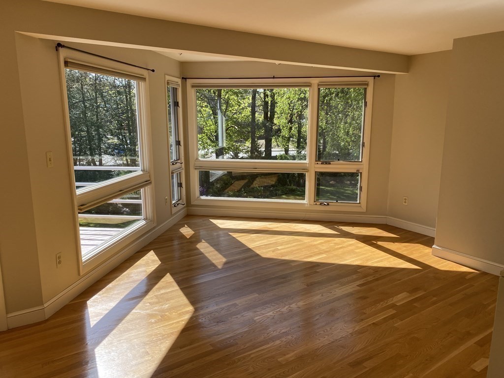 490 Concord Road Sudbury, MA 01776 - Photo 14 of 31 a view of empty room with wooden floor and floor to ceiling windows