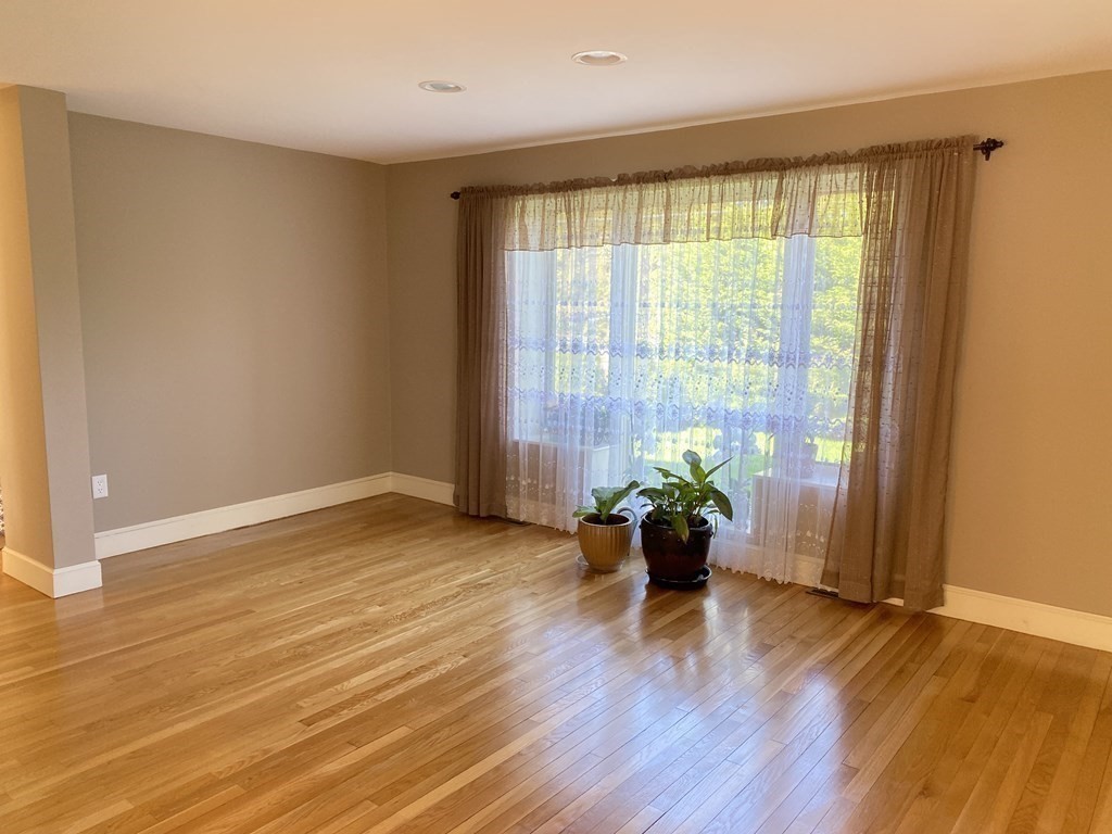 490 Concord Road Sudbury, MA 01776 - Photo 6 of 31 a view of an empty room with wooden floor and a window