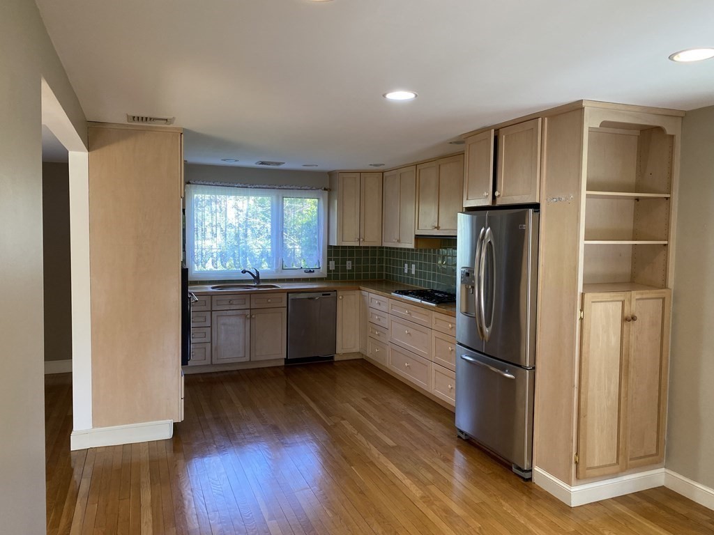 490 Concord Road Sudbury, MA 01776 - Photo 8 of 31 a kitchen with a refrigerator a sink and cabinets
