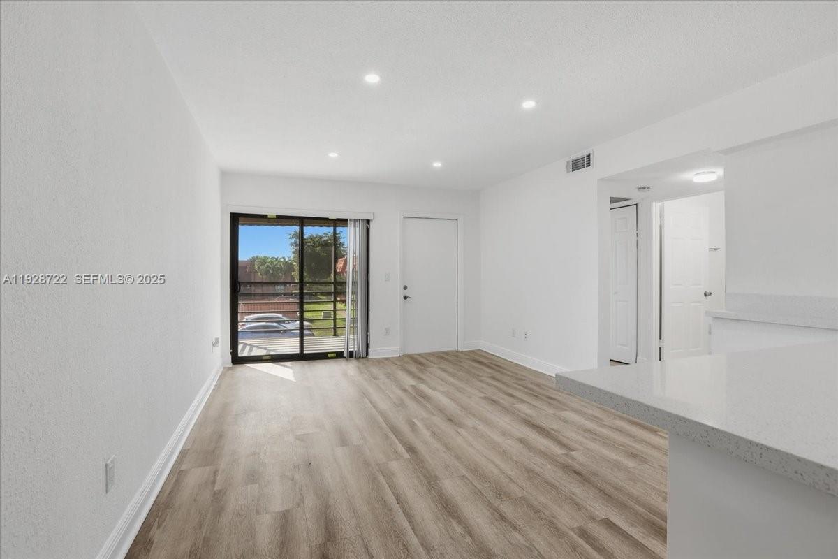 Hialeah Hialeah, FL 33016 - Photo 8 of 32 a view of an empty room with wooden floor and a window