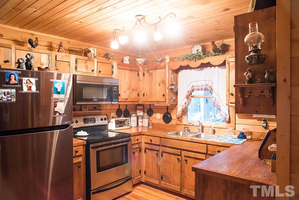 3520 Bowmantown Road Roxboro, NC 27574 - Photo 13 of 24 a kitchen with stainless steel appliances a stove and a refrigerator