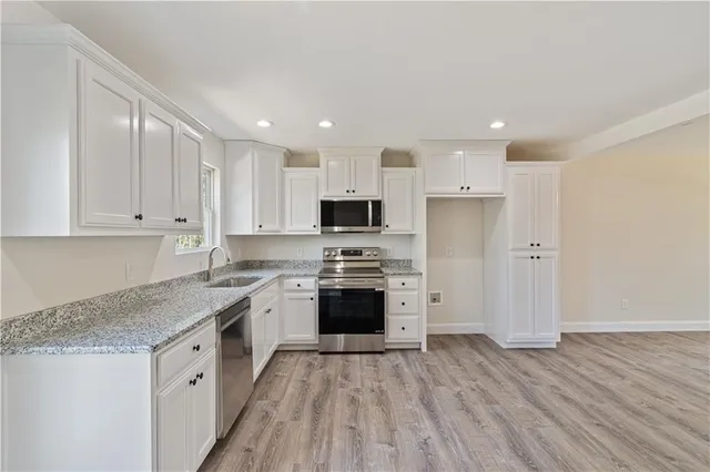 a kitchen with stainless steel appliances granite countertop a stove a sink and a refrigerator