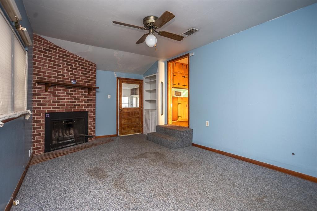 1414 Rice Avenue Gainesville, TX 76240 - Photo 16 of 21 a view of an empty room with a fireplace and a window