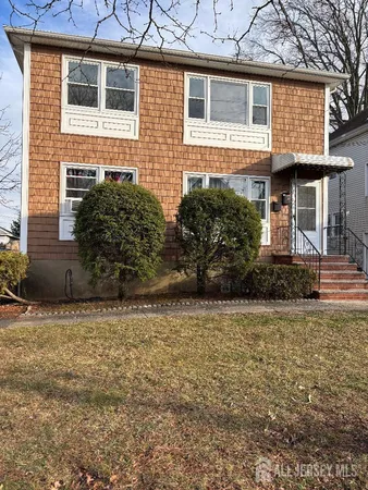a front view of a house with plants