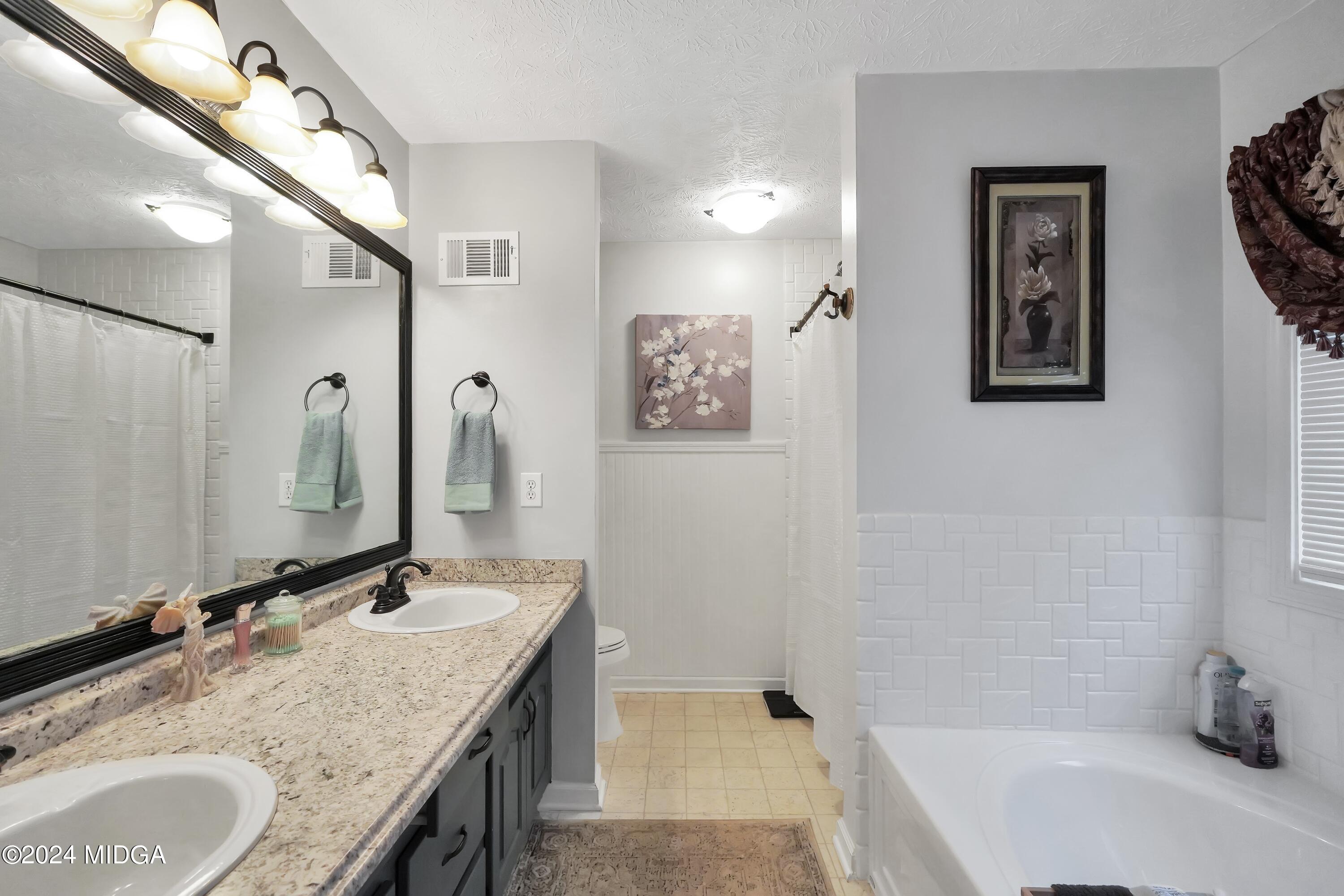 208 Brown Branch Road Locust Grove, GA 30248 - Photo 19 of 44 a bathroom with a granite countertop tub sink and mirror
