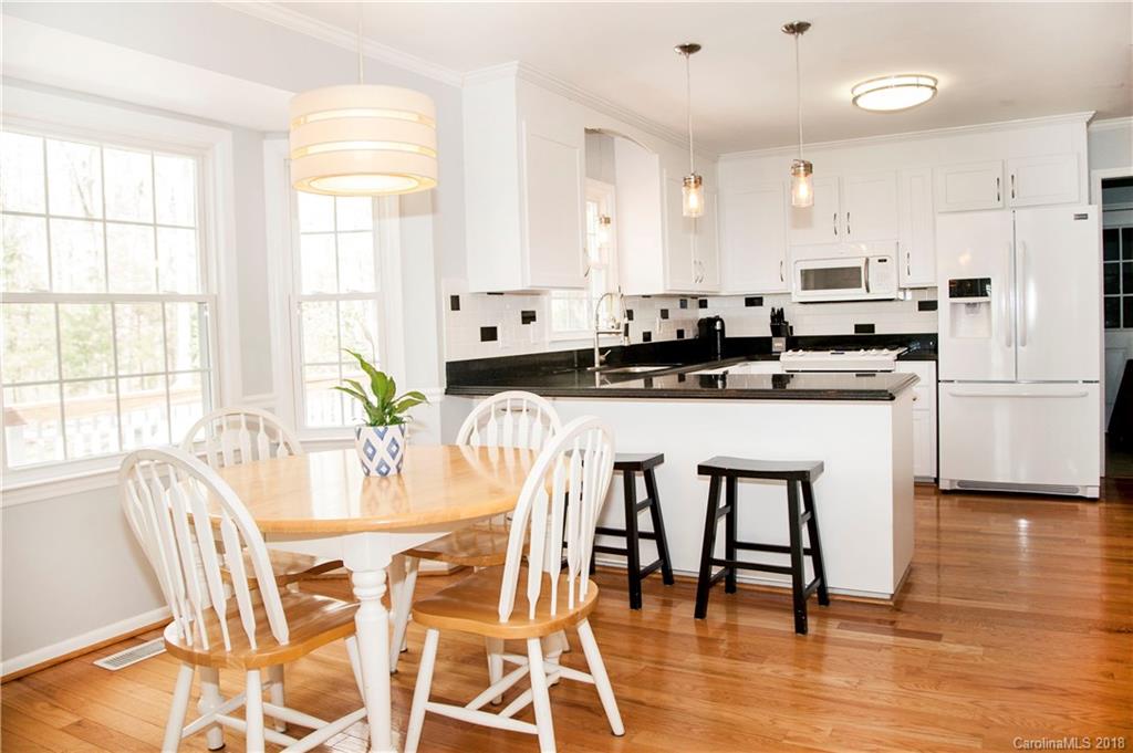 2751 Farmstead Lane, Unit 63 Fort Mill, SC 29708 - Photo 9 of 30 a kitchen with stainless steel appliances granite countertop a stove top oven a sink a dining table and chairs